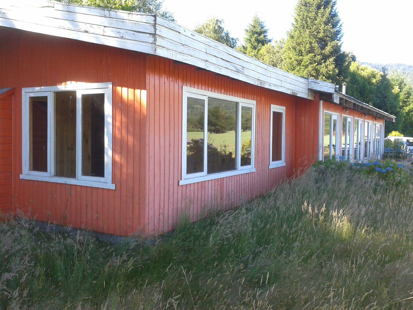 Estado original: fachada lateral de dormitorios y terraza homify Casas rurales Madera Acabado en madera