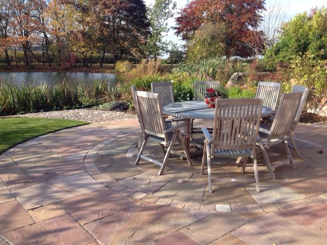 A Cheshire Country Garden Charlesworth Design Jardines de estilo rural patio,terrace,dining chair,dining table,lake,pool,countrygarden,cheshire garden,paving,cobbles