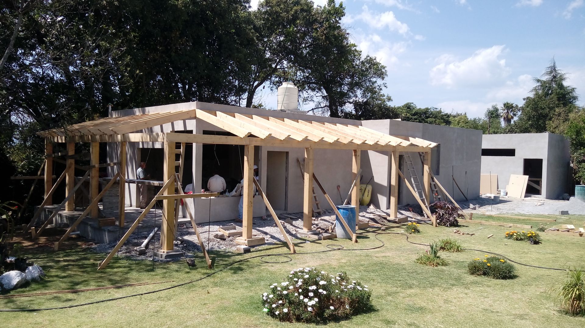 Vista de fachada principal con pergolado de madera en proceso de colocación. taller garcia arquitectura integral Casas rurales