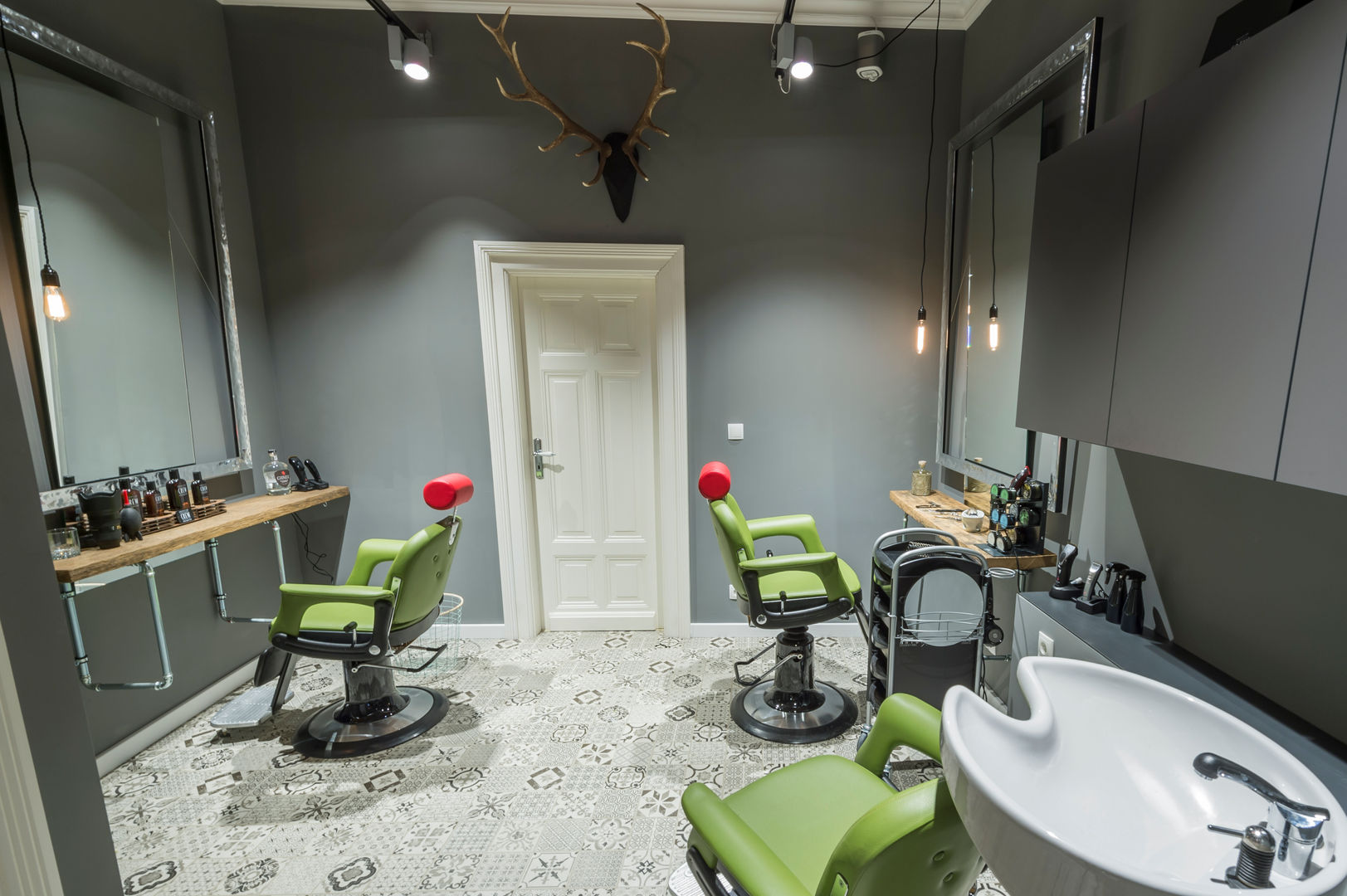 Barber Kundenbereich Gesamtüberblick hysenbergh GmbH | Raumkonzepte Duesseldorf Gewerbeflächen Wände grau,Barbershop,Kundenbereich,Stabglühbirne,Hirschgeweih,Mosaikfliesen,Musterfliesen,Spiegel,Deckenspots,Waschbereich,Ladenflächen