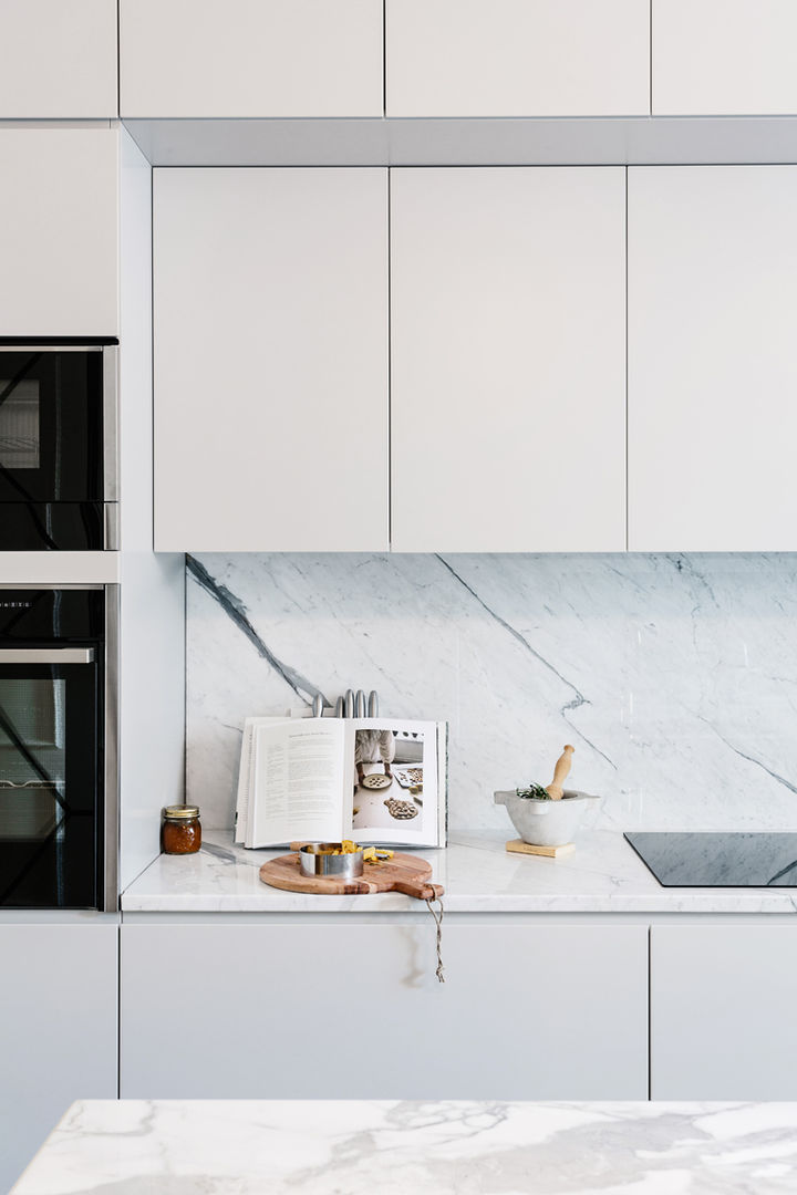 Una cucina con un'isola verde con piano di lavoro bianco e una