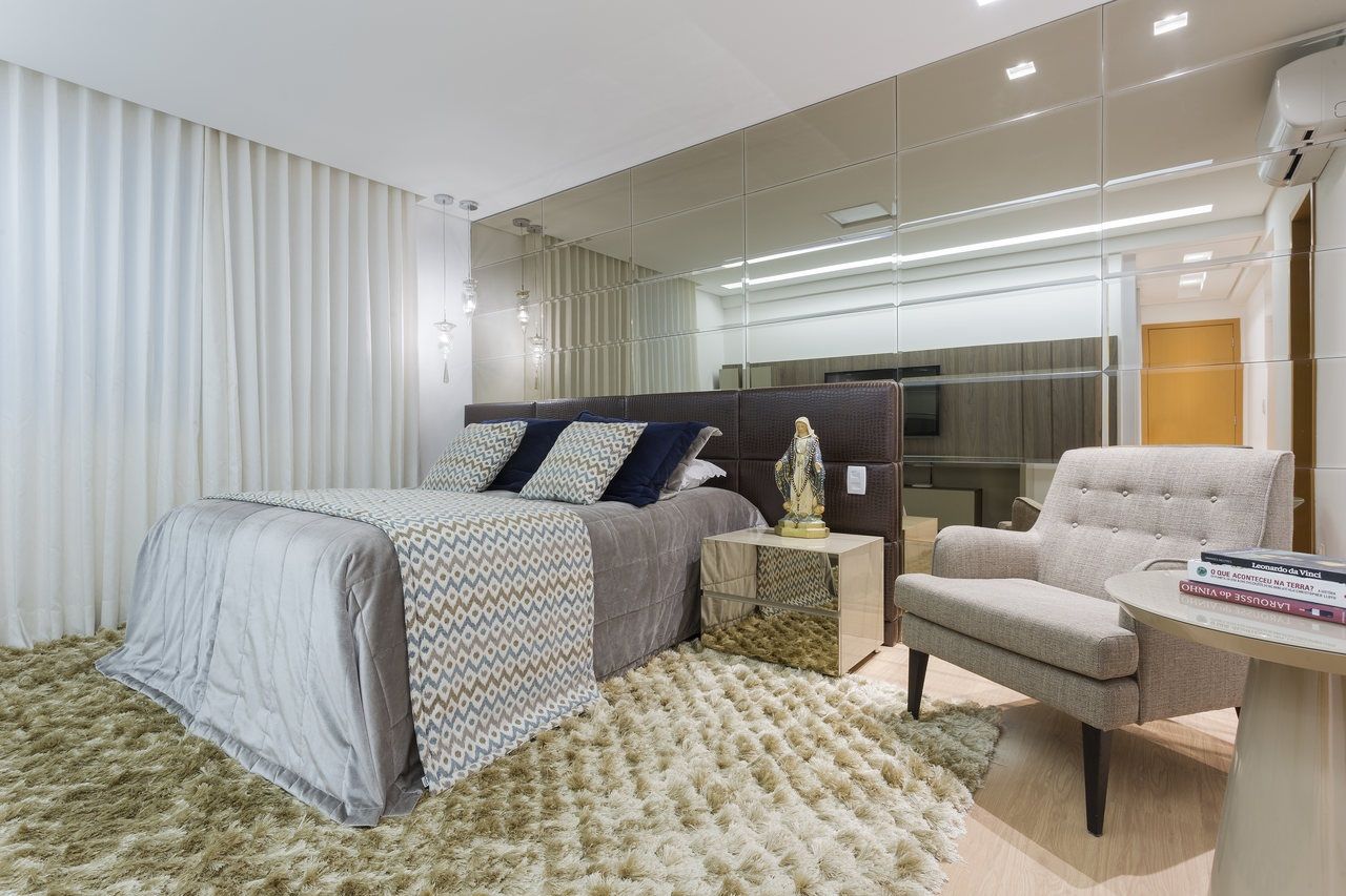 Suite do casal JANAINA NAVES - Design & Arquitetura Quartos ecléticos MDF espelho no quarto,sofa no quarto,espelho bronze