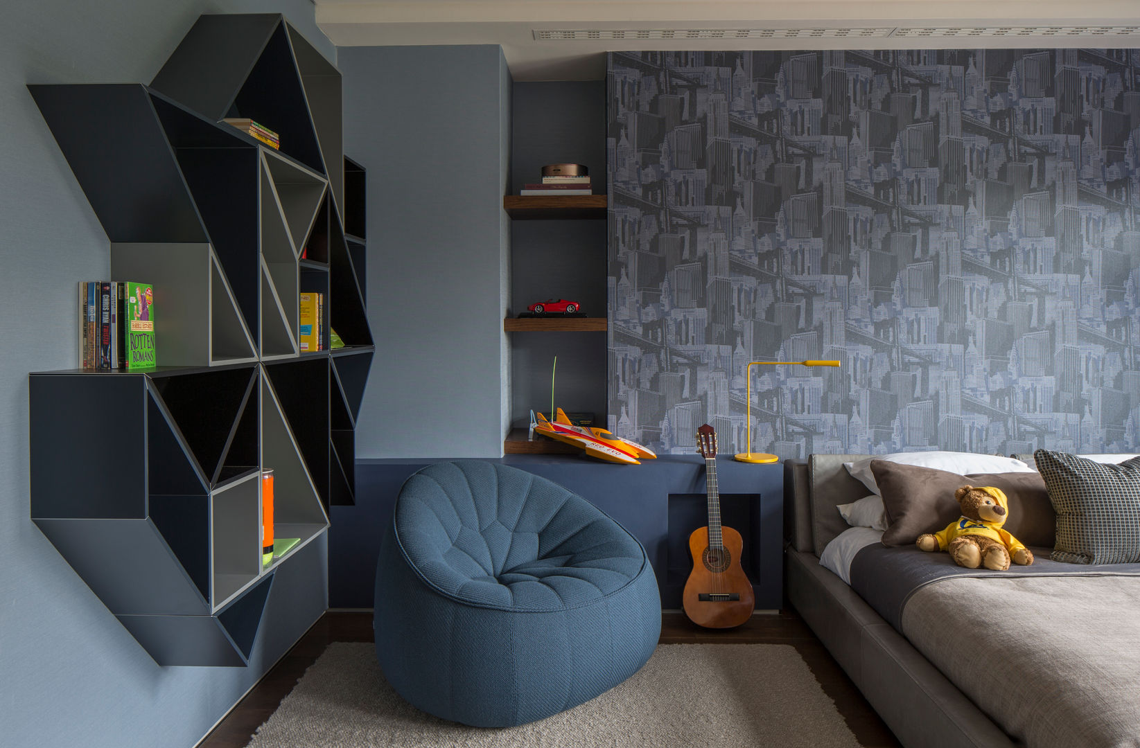 Broad Walk Children's Bedroom Roselind Wilson Design Habitaciones para niños de estilo moderno interior design,luxury,textured walls,colourful wall paper,geometric shelving,blue and grey,storage space,patterned wall paper,blue pouffe,children's bedroom