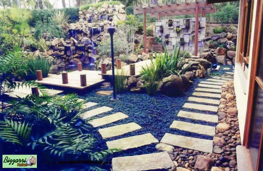 Caminhos com pedra rústica no jardim com o lago de carpas, a ponte de madeira que leva até o pergolado de madeira. Casa em condomínio em Atibaia-SP. Bizzarri Pedras Jardins rústicos Pedra Caminho de pedra,Caminho com pedra,Paisagismo com pedra