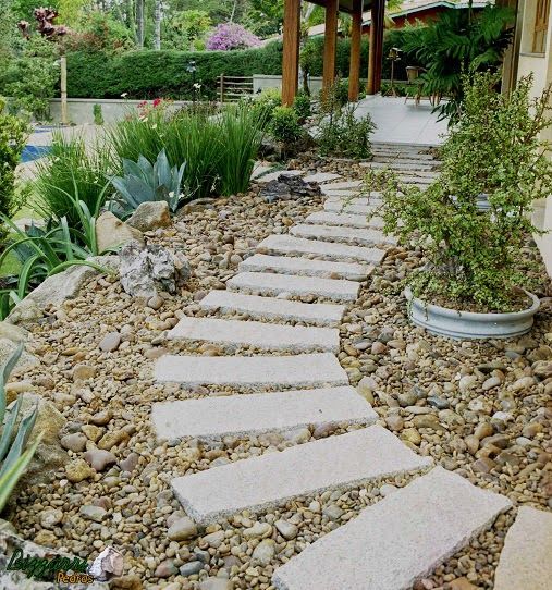 Caminho com pedras no jardim com pedregulho de rio para rebater a água que cai do telhado. Casa em condomínio em Atibaia-SP. Bizzarri Pedras Jardins rústicos Pedra Caminho de pedra,Caminho com pedra,Paisagismo com pedra