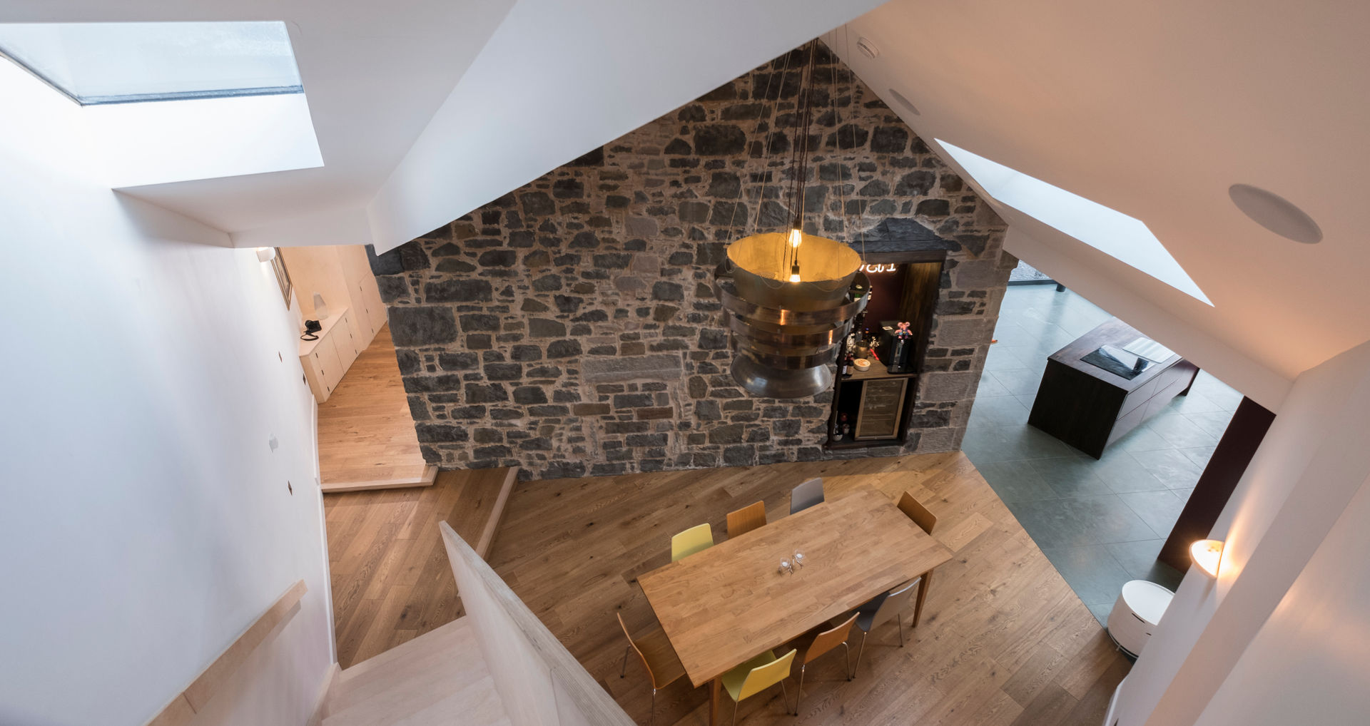 View from staircase over the dining room Woodside Parker Kirk Architects غرفة السفرة حجر Rooflight,Bespoke,Staircase,Plywood,Reclaimed,Lighting,Dining room,Stone wall,Original features,wood flooring