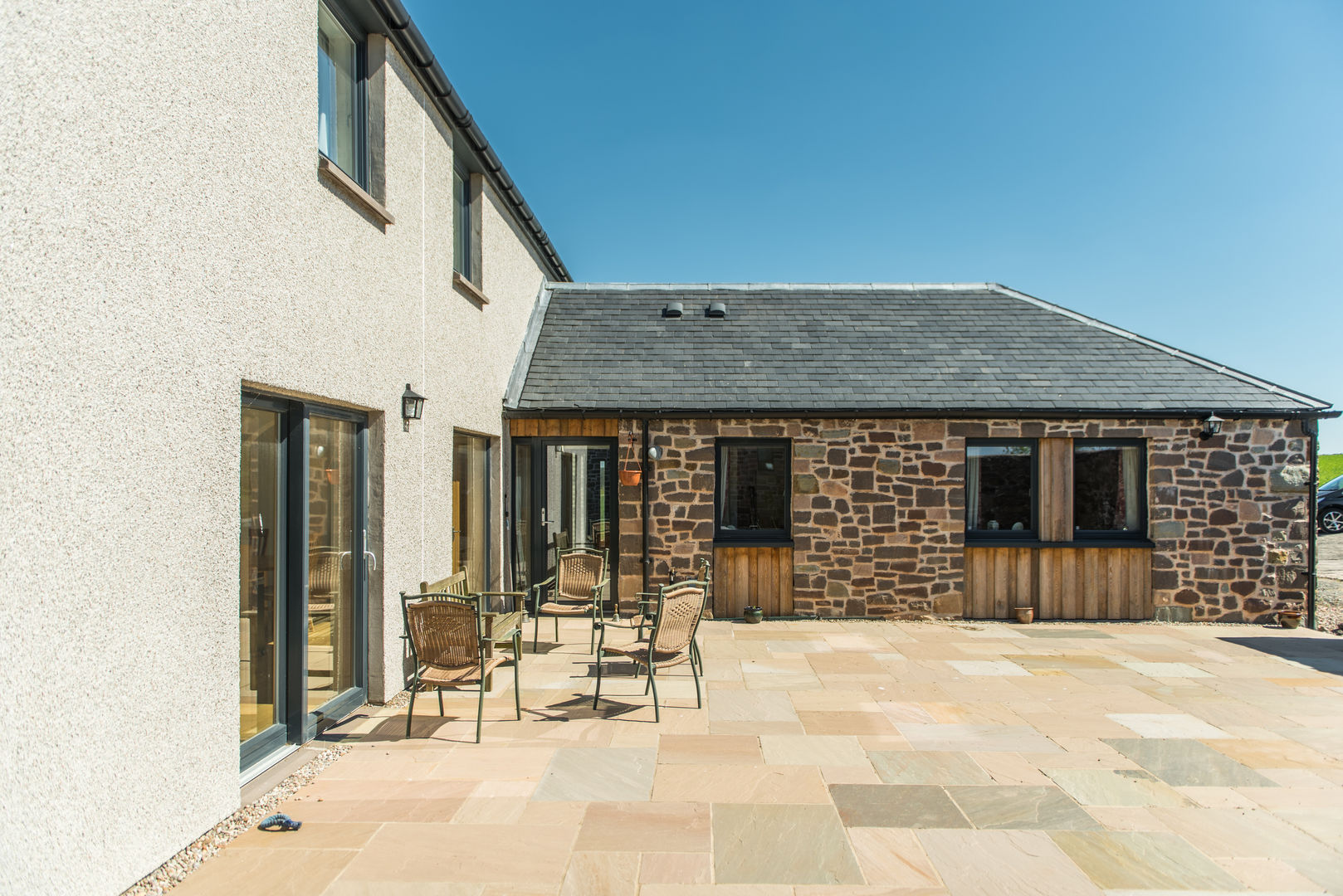 Sun trap patio space Woodside Parker Kirk Architects Balcones y terrazas rurales patio,sun trap,courtyard,stone house,render,alu-clad windows,pitched roof