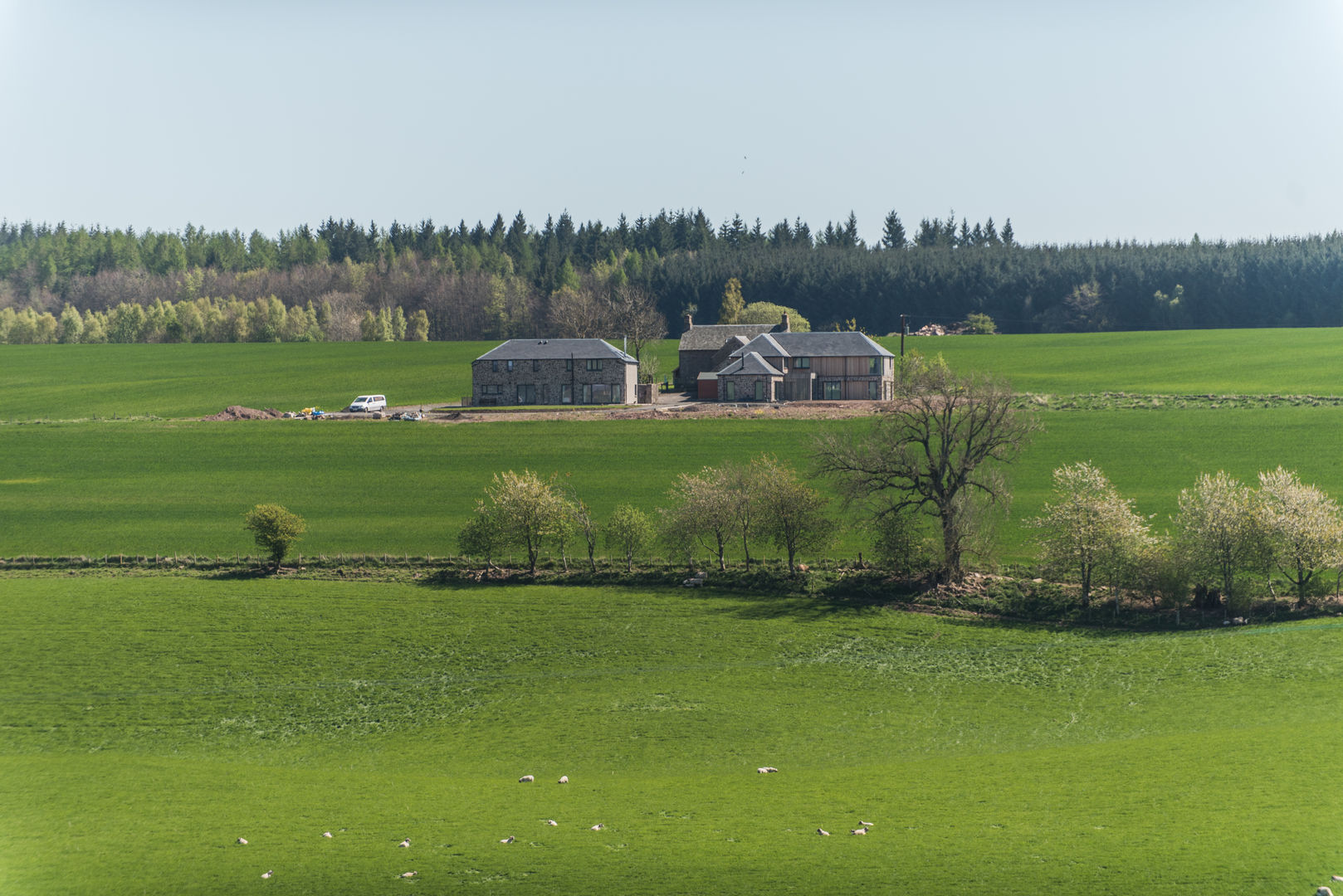 The development sits within the landscape as the former farm steading would Woodside Parker Kirk Architects Landelijke huizen rural,architecture,farm steading,development,new build,new house,stone house,landscape,countryside,view