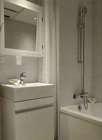 以『仿圓形馬賽克效果壁磚』與『復古溫暖木紋六角蜂巢地磚』，圍塑出北歐風格效果的衛浴空間。 大觀創境空間設計事務所 Modern bathroom
