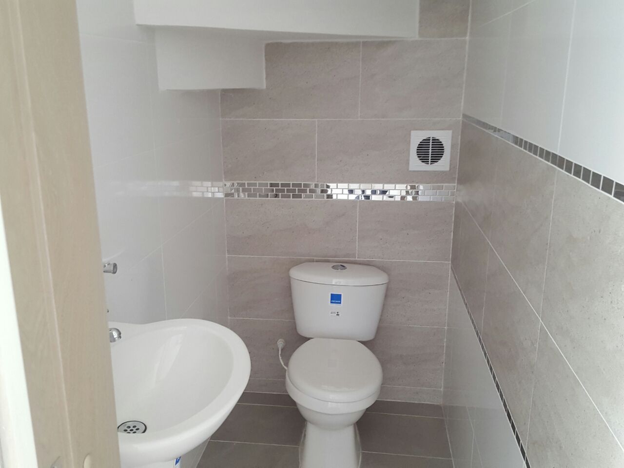 Cuarto de baño simple y moderno con azulejos de mármol blanco acabado de  madera inodoro y ducha
