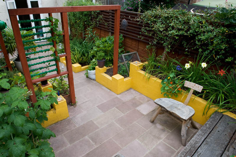 Raised planters and sandstone patio Earth Designs حديقة sandstone,patio,slabs,terracotta,yellow,screen,chair,wooden