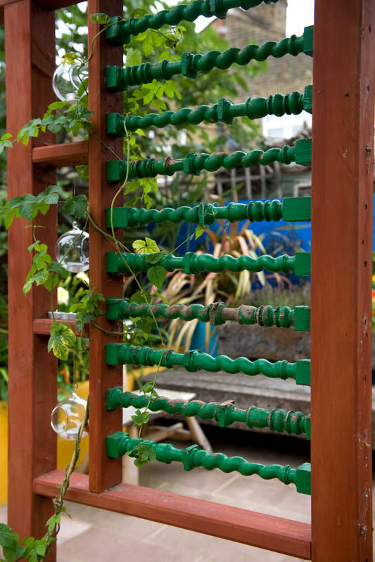 Reclaimed spindles set into garden screen Earth Designs Jardines mediterráneos recycling,salvage,upcycling,gardenscreen,eastlondon,spindles,timber,london