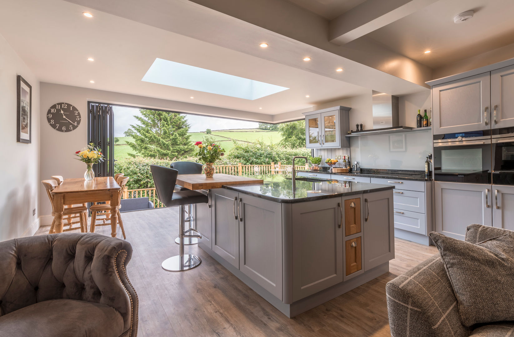 An open view of the High Peak John Gauld Photography モダンな キッチン Kitchen island,bifold doors