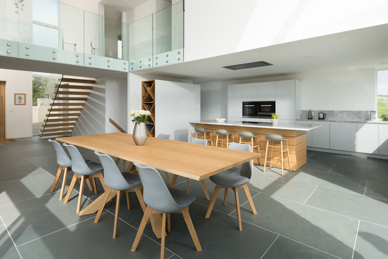 Contemporary Replacement Dwelling, Cubert, Laurence Associates Laurence Associates Modern dining room kitchen,dining room,open plan,open space kitchen,dining table,dining chairs,mezzanine,stairs,white kitchen,flooring,modern,contemporary