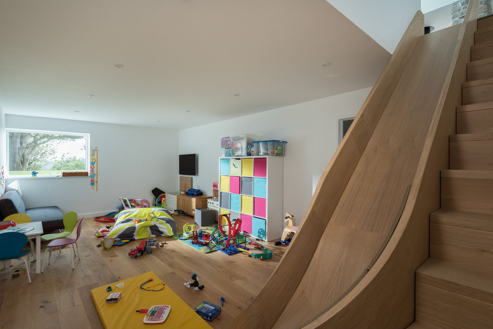Contemporary Replacement Dwelling, Cubert, Laurence Associates Laurence Associates Quarto infantil moderno play room,game room,internal slide,fun,games,storage,children,toys,modular storage,bright colours,play,kids room