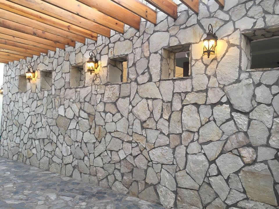 MURO DE PIEDRA LAJA EN CORREDOR PRINCIPAL homify Paredes y suelos de estilo rural Piedra