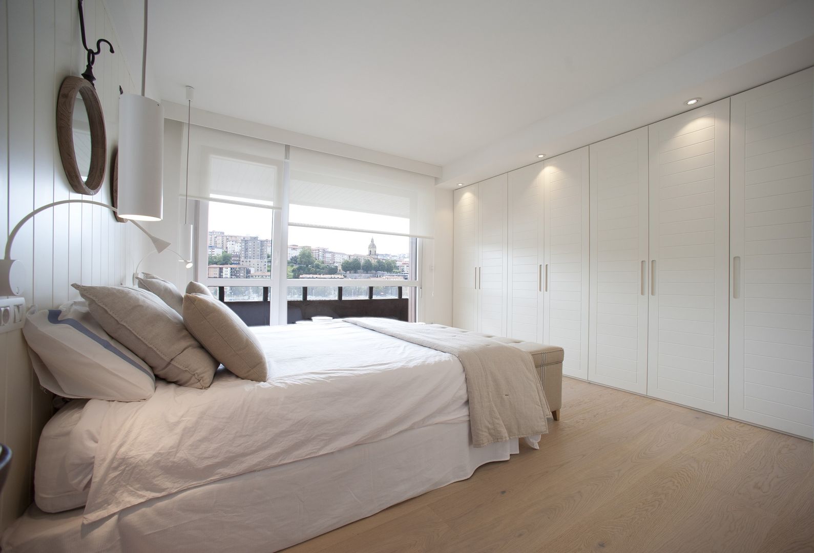 Reforma de vivienda en madera, blanco y tonos azules Sube Interiorismo Dormitorios de estilo clásico cama doble,armario empotrado,madera pintada de blanco,blanco,iluminación,suelo de madera,casa blanca