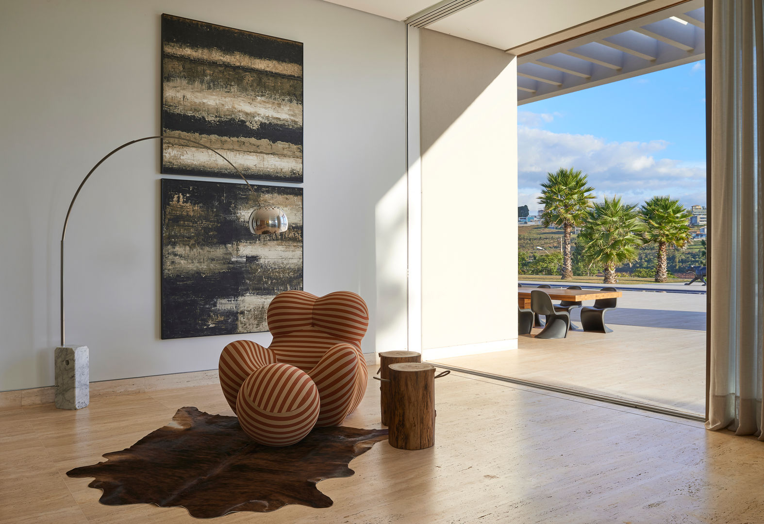 Canto da sala de estar, destaque para a poltrona Donna; piso de Travertino, pintura branca, esquadrias de alumínio Lanza Arquitetos Salas de estar modernas Sintético Castanho Acessórios e Decoração