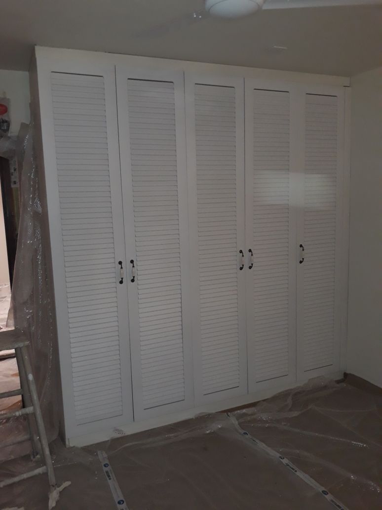 Hinged door louvered wardrobe installed by Zenia homify Country style bedroom MDF