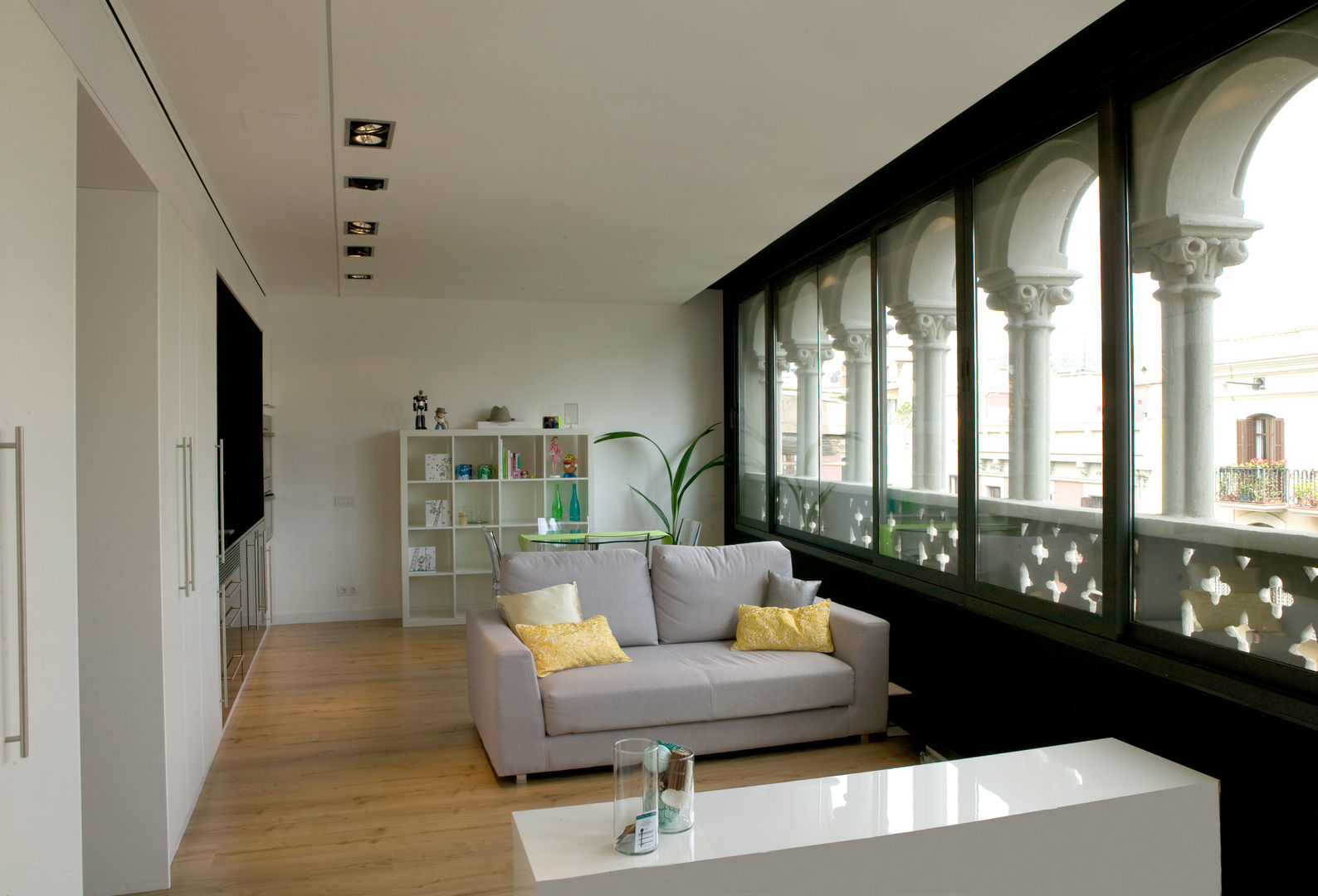 Salón comedor con sofá pequeño gris y suelo de parquet projectelab Escaleras Compuestos de madera y plástico