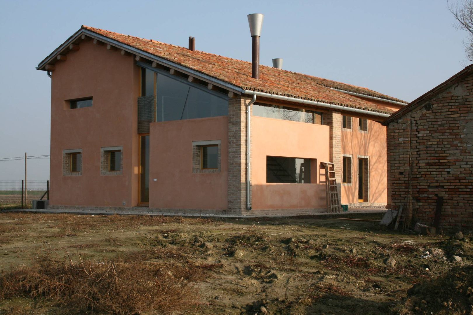 Lato Est Massimo Berto Architetto Casa di campagna Laterizio vetrata,vetrata triangolare,camini alla veneta