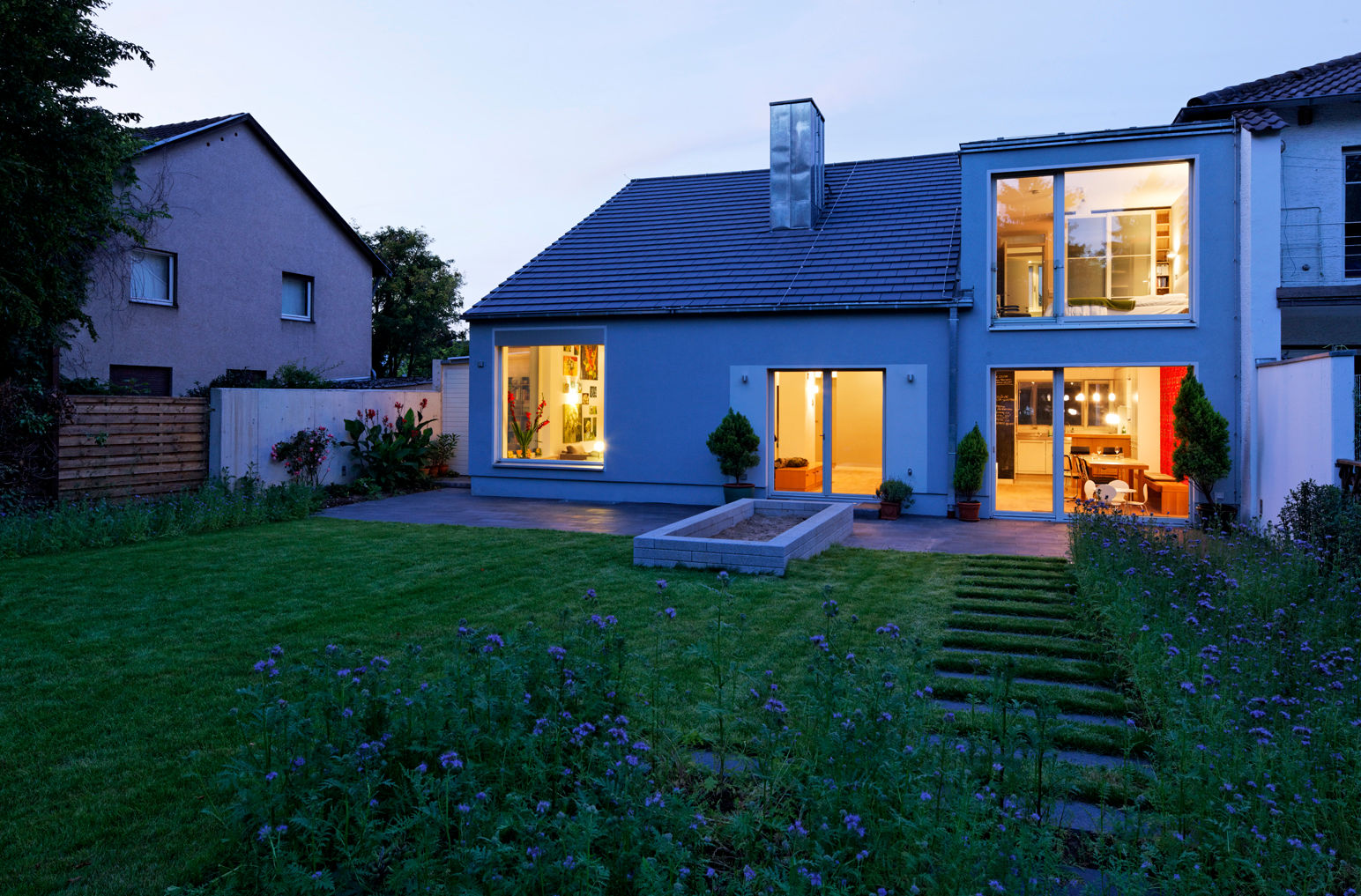 Blick vom Garten zur blauen Stunde Grotegut Architekten Einfamilienhaus Fassade,Garten,Terrasse,Grau,Einfamilienhaus,Nachtlicht,Außenbeleuchtung