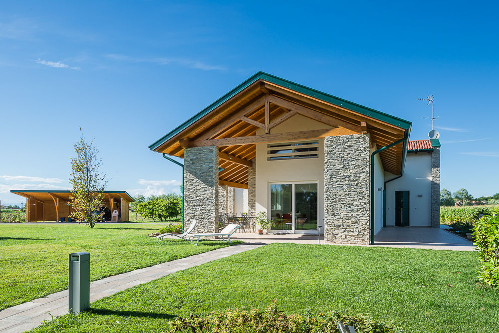 Una villa immersa nel verde, Woodbau Srl Woodbau Srl Casas de madera Piedra