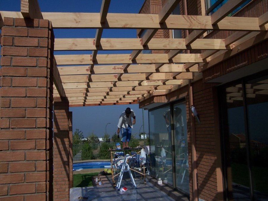 Pérgola en PVC entre muros textura madera