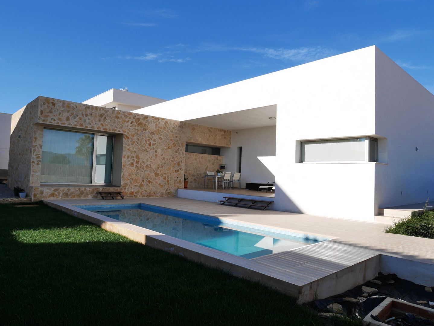 Fachada recayente al jardin de la casa y piscina linkehome arquitectura Casas unifamiliares Piedra