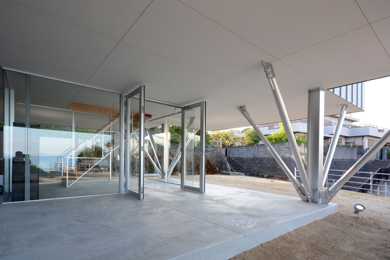 Entrance porch 土居建築工房 Modern corridor, hallway & stairs Aluminium/Zinc House Pilotis Overlooking the sea Entry Hall Porch