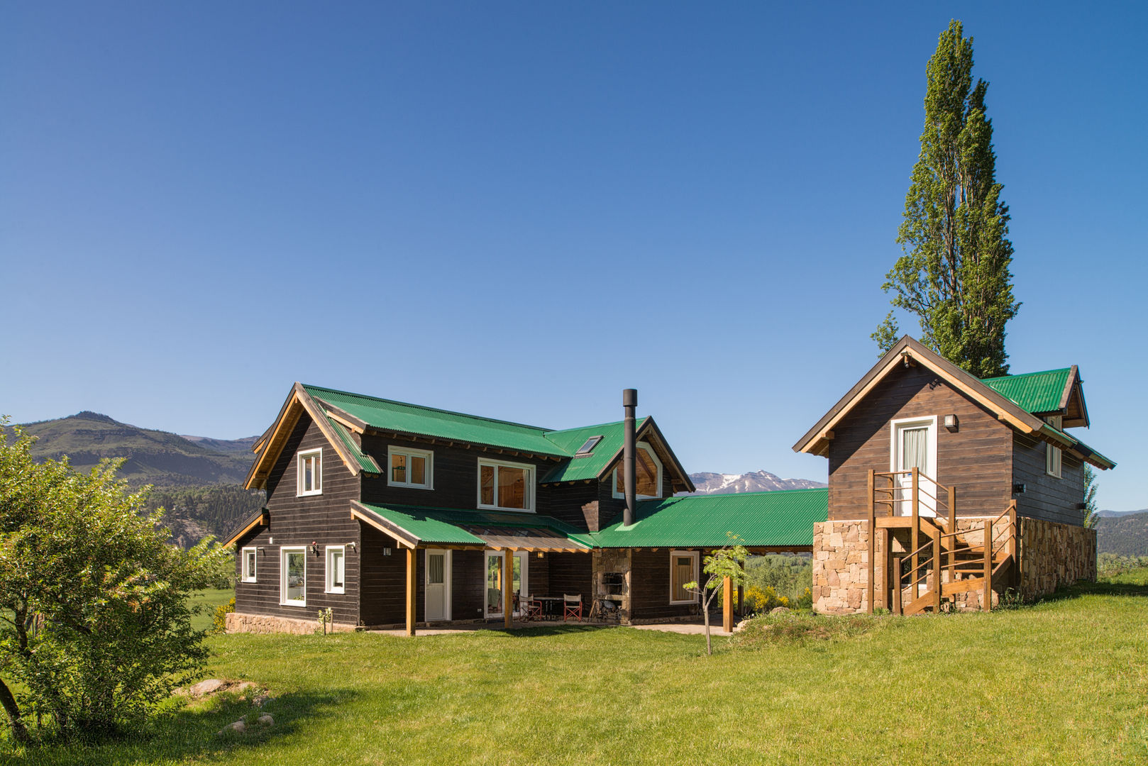 Frente de casa en la montaña I Patagonia Log Homes Patagonia Log Homes - Arquitectos - Neuquén Casas de madera Madera maciza Acabado en madera casa de madera,madera,exterior de madera,columna de madera,piso de madera,viga de madera,mobiliario de exterior,casa de piedra