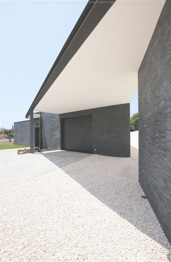 Entrada na garagem da casa OGGOstudioarchitects, unipessoal lda Casas minimalistas Quinta da Bela Vista,Moradia,Algarve,garagem,muros,xisto