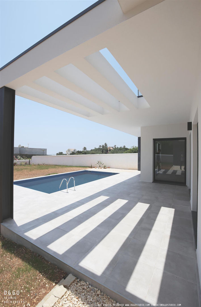 Espaços exteriores da casa OGGOstudioarchitects, unipessoal lda Casas minimalistas Quinta da Bela Vista,moradia,Algarve,Piscina,alpendre,pala