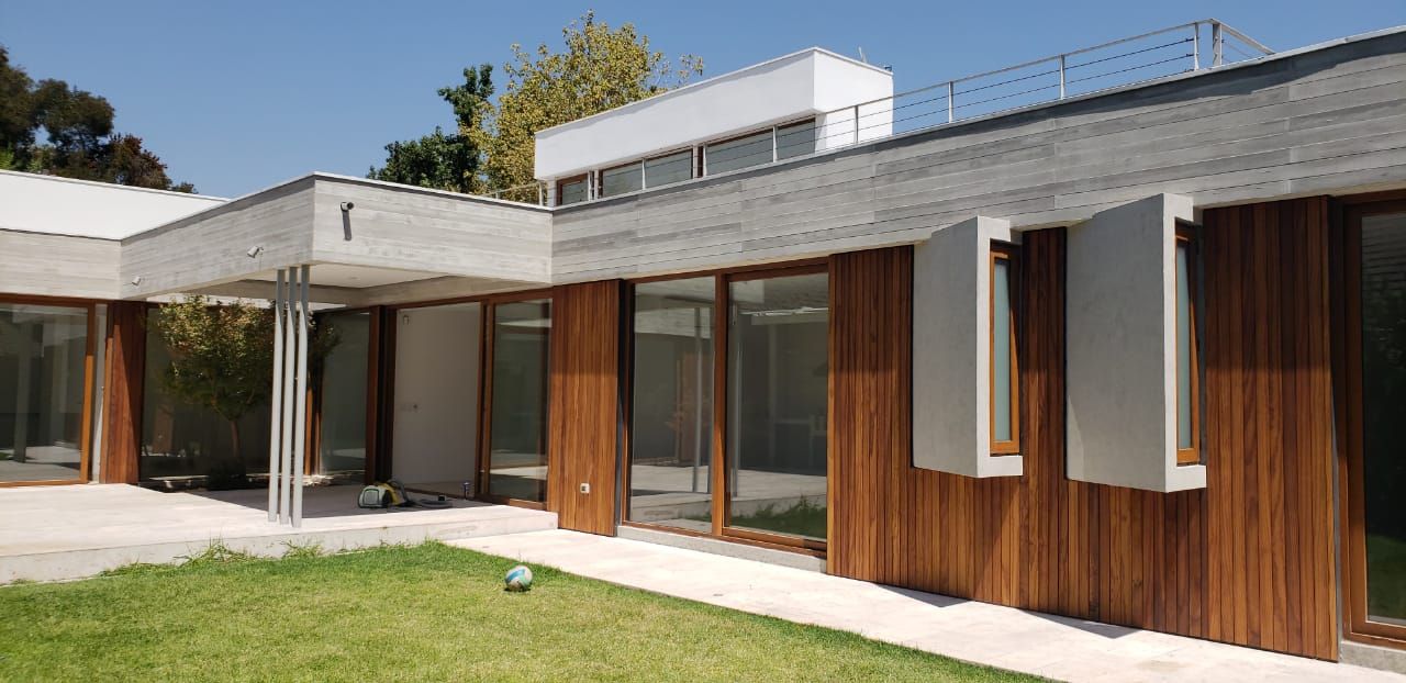 Fachada de madera y porcelanato Constructora CYB Spa Casas unifamiliares