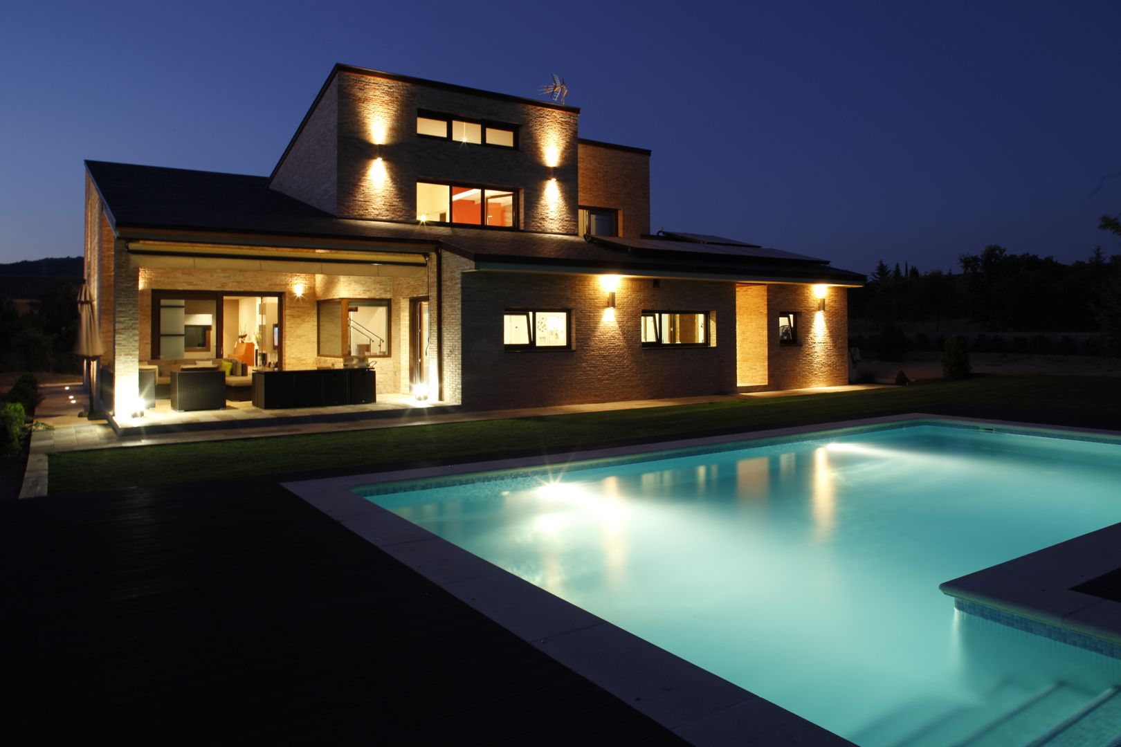 Fachada trasera con piscina Domonova Soluciones Tecnológicas Casas de estilo moderno iluminación exterior,domotica