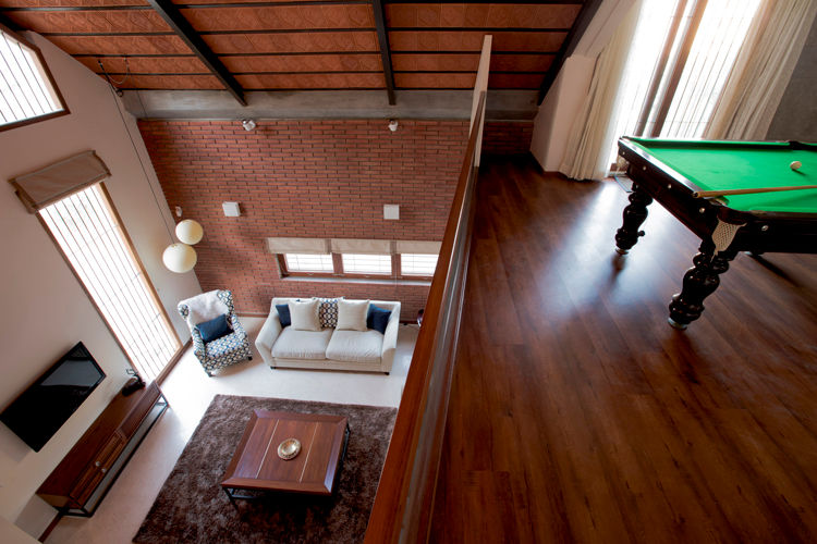 Pool Table space overlooking the living below Kamat & Rozario Architecture Modern living room Bricks pool table