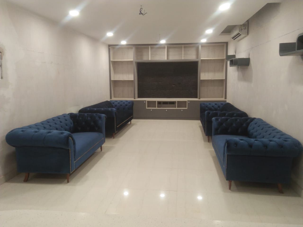 Basement at Noida, Grey-Woods Grey-Woods غرفة المعيشة حجر خزانات التلفزيون الجانبية