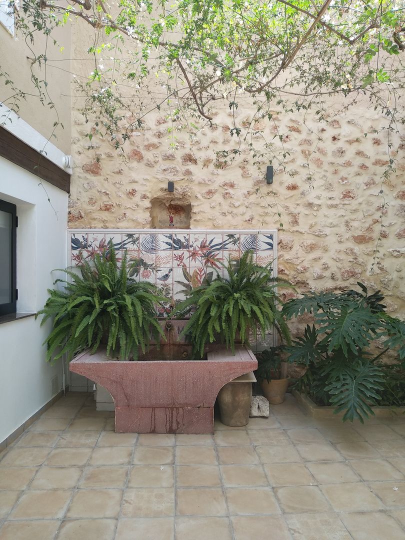 Reforma de pila antigua en el patio central de la casa Gestionarq, arquitectos en Xàtiva Balcones y terrazas rústicos Piedra