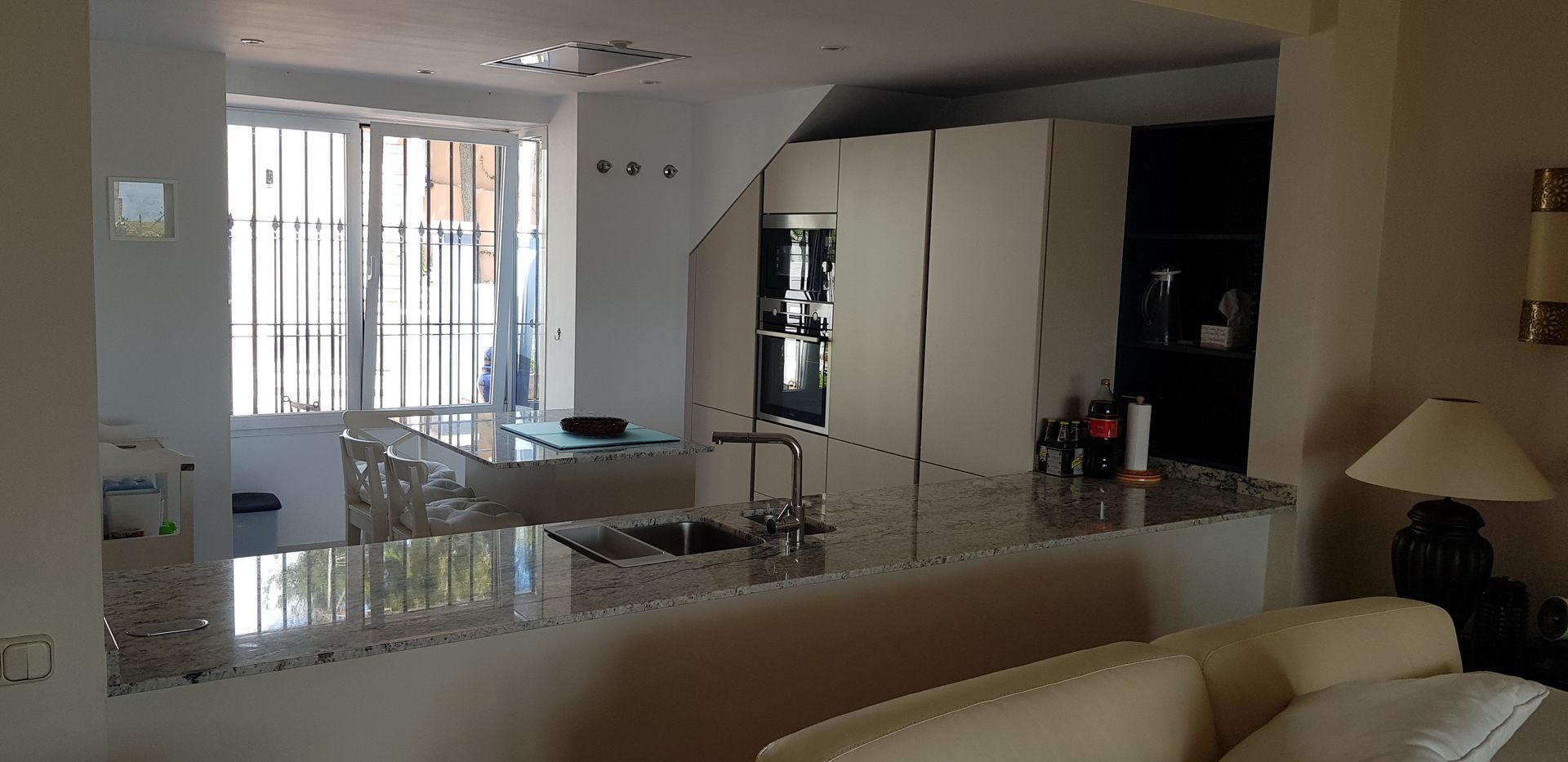 Cocina abierta al salon con encimera de granito Naturamia Decodan - Estudio de cocinas y armarios en Estepona y Marbella Cocinas integrales