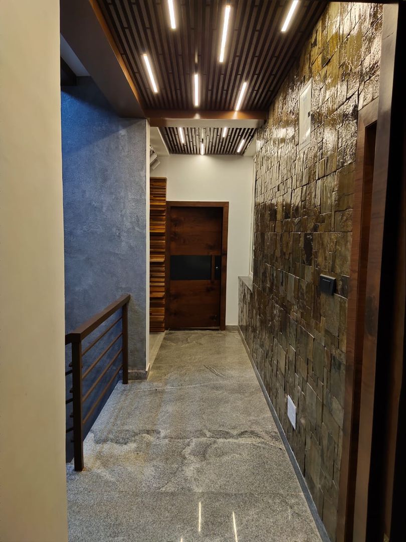 Hallway designed with stone cladding on wall and asymetric wooden ceiling with linear lighting Enwave Modern corridor, hallway & stairs