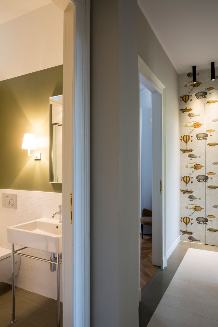 Il corridoio e il bagno ospiti Matteo Magnabosco Architetto Ingresso, Corridoio & Scale in stile moderno cementine carta da parati verde oliva piastrelle bianche lavabo lavandino consolle ospiti specchio fornasetti