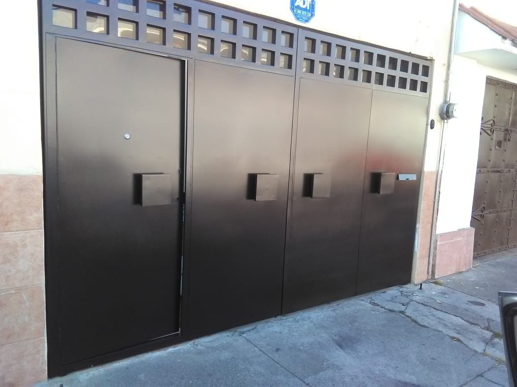 Puerta abatible de dos hojas con una puerta peatonal integrada. PUERTAS AUTOMÁTICAS GROSSMANN Puertas de entrada Metal