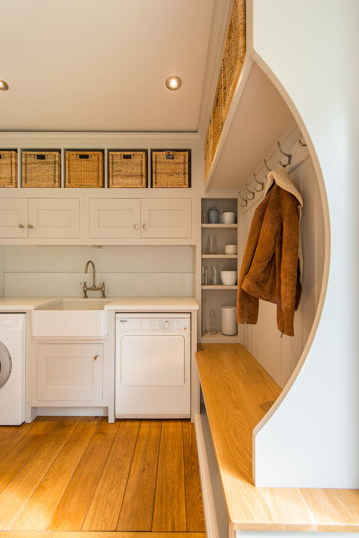 Utility room storage bench with curved end panel by Christopher Howard Christopher Howard Built-in kitchens لکڑی Wood effect utility room, boot room, bespoke storage, bespoke cabinets, shaker style cabinets, laundry room, grey cabinets, white cabinets, Belfast sink, Quartz worktop, splash back, traditional tap, chrome handles, Miele