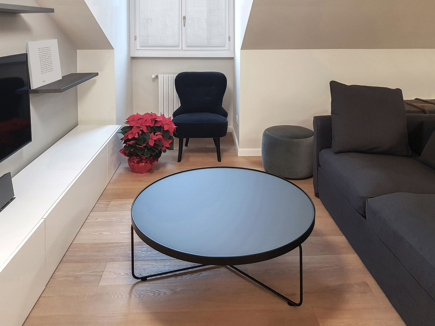 Mansarda in Milano, Magenta - Airbnb - 70mq Bongio Valentina Soggiorno moderno airbnb, divano grigio, mansarda, mensole grigie, mobile tv bianco, parete grigia, pareti bianche, parquet, pavimento in legno, poltrona in velluto, pouf in velluto grigio, ristrutturazione, soggiorno, tavolino rotondo, televisione a parete