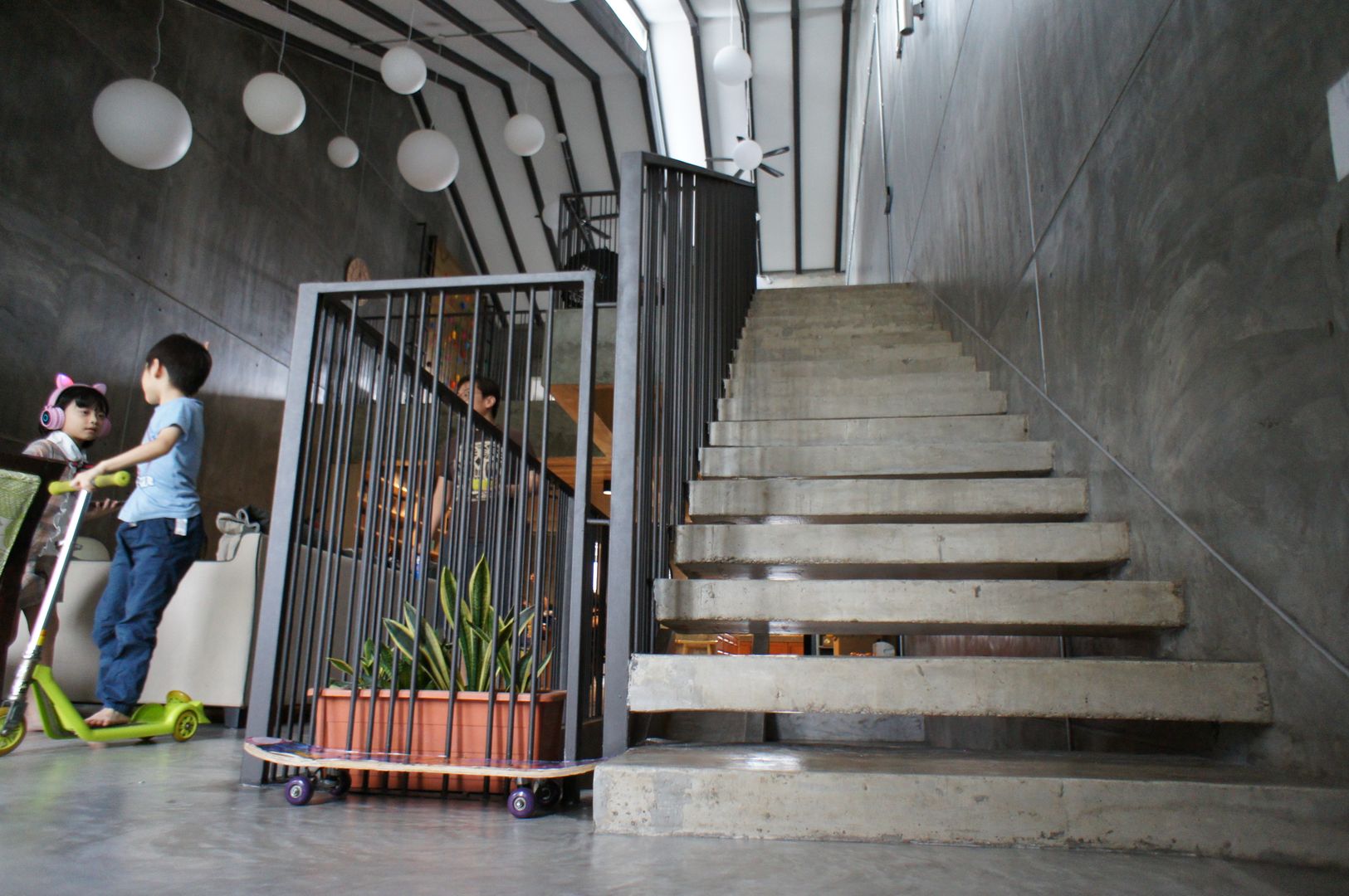 Wall protruded concrete slab steps, complimented with vertical sleek metal railing N O T Architecture Sdn Bhd Stairs