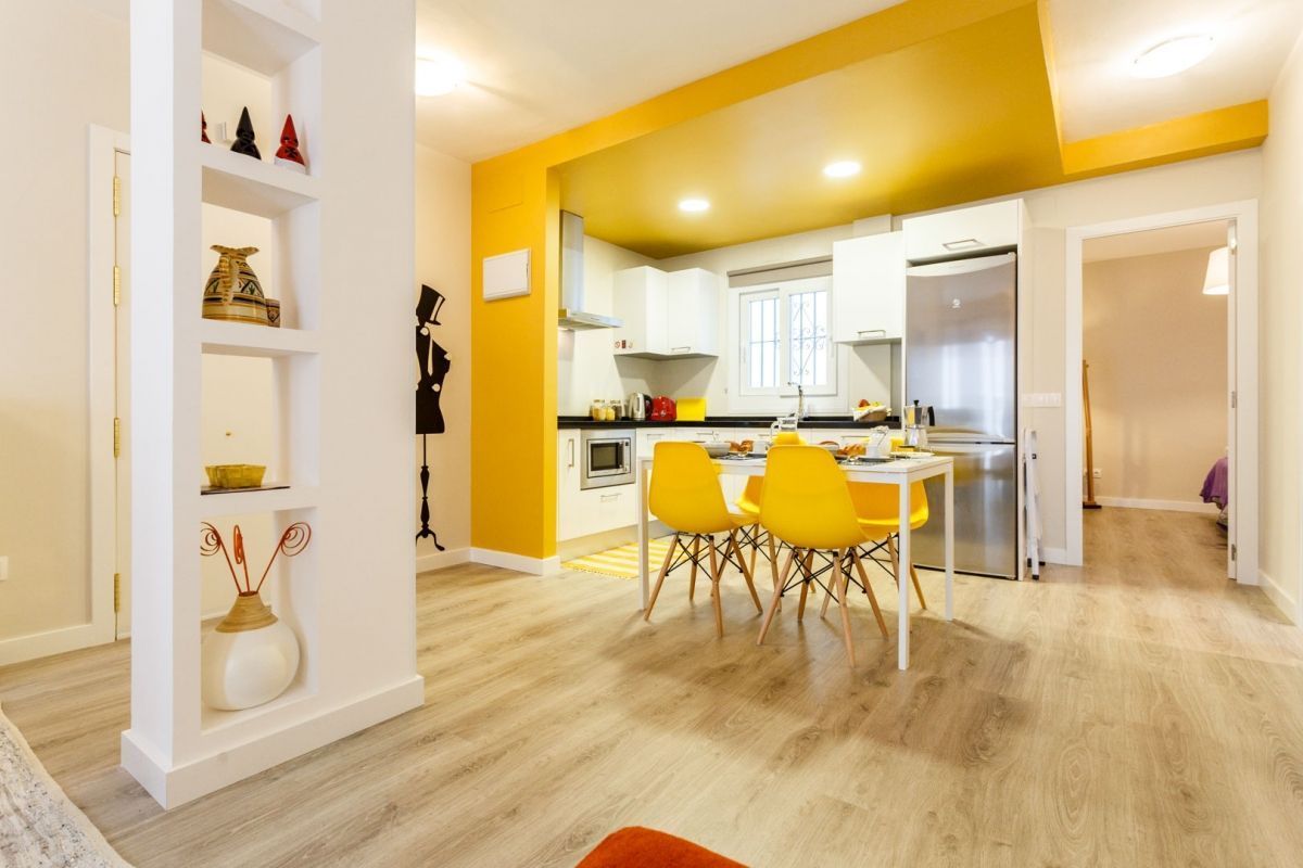 Cocina de estilo moderno con mueble de cocina naranja, mesa y silla