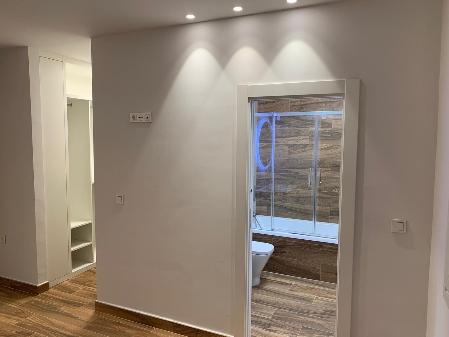 Entrada a baño y vestidor desde dormitorio principal Techluz Iluminación Dormitorios modernos: Ideas, imágenes y decoración