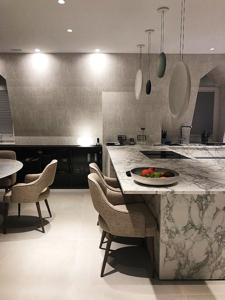vista cucina e sala da pranzo Luisa Olgiati Cucina moderna top in lastre gres effetto marmo, illuminazione Vibia, oggetti di design