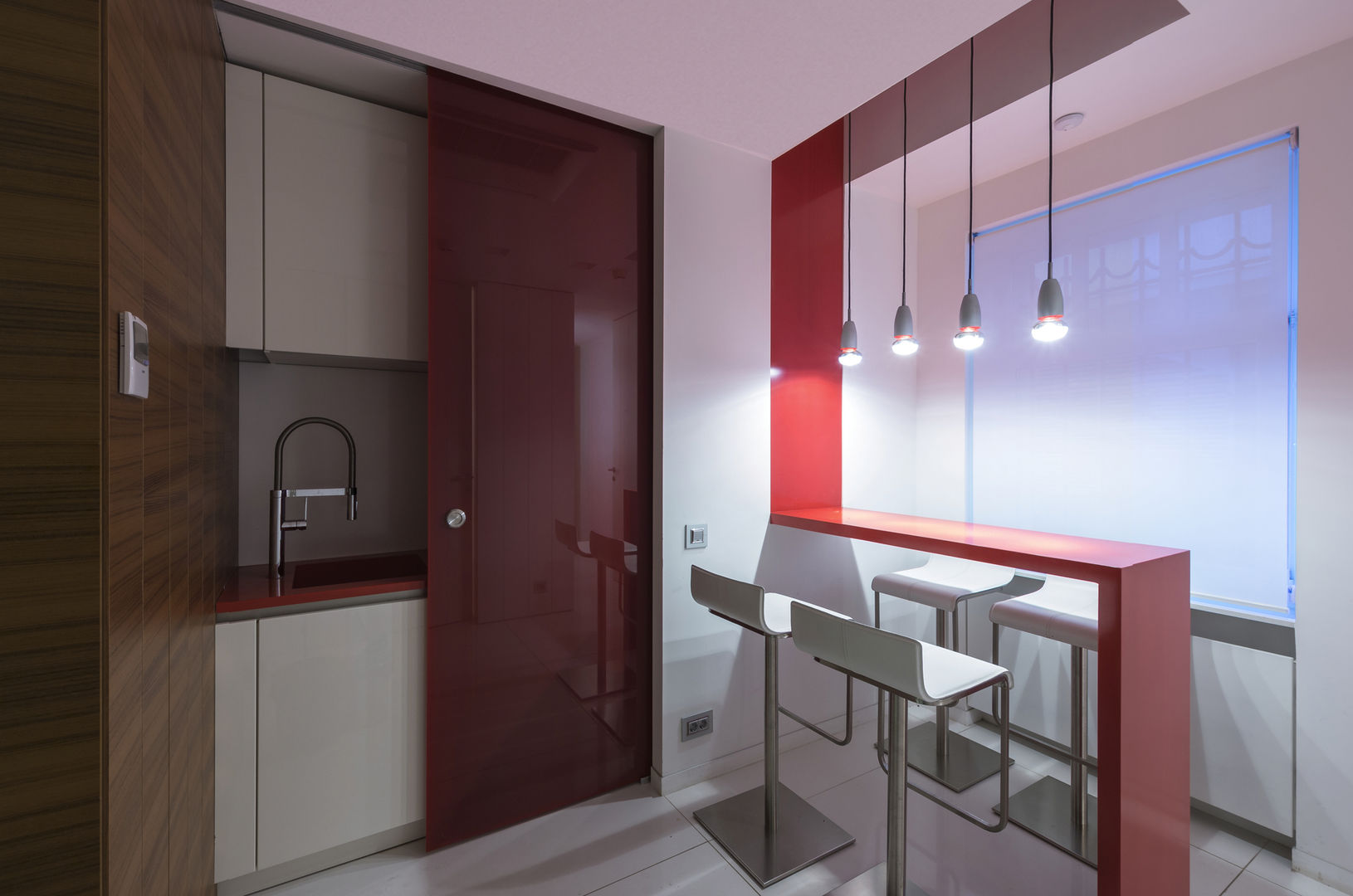 Kitchen furniture in white lacquered structure and red Corian top, Moscow office homify Modern kitchen لکڑی Wood effect sliding pocket doors, red kitchen, red sliding doors, sliding doors covered in teak wood boiserie, teak wood wall coverings,Cabinets & shelves